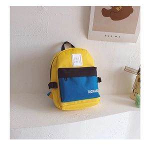 Détail d'un sac à dos enfant coloré avec design contrasté jaune et bleu et poche avant