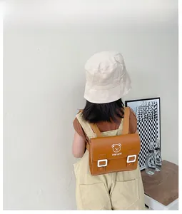 Detail of vintage brown PU leather kids backpack with a cute bear and Stay Cute text