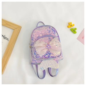 Détail d'un sac à dos enfant à paillettes violettes avec nœud rose et décor sirène