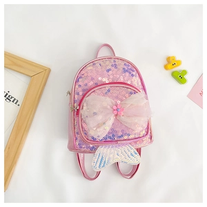 Détail d'un sac à dos rose à paillettes pour enfants avec nœud et queue de sirène