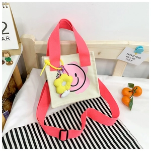 Close-up of smile flower canvas tote with pink handles and yellow decorative pendant