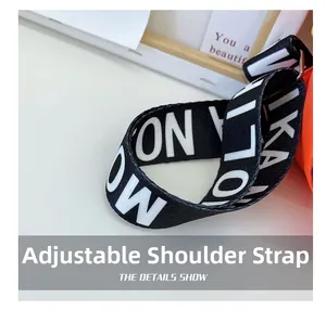 Close-up of adjustable black and white jacquard wide shoulder strap with metal buckles