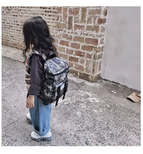 Detail showing jungle camouflage pattern and white NY logo on durable kids backpack