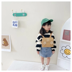 Close-up of khaki mini backpack with Stay Cute bear logo on textured PU material