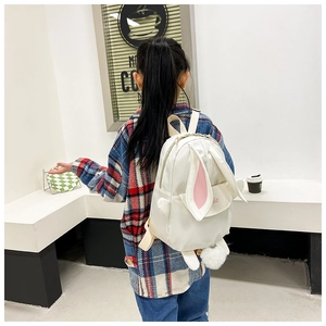 Detail showing plush pompom and cute bunny ears on white lightweight children backpack