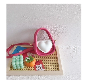 Détail d'un mini sac à main coeur rose et blanc pour fille avec bandoulière réglable chic
