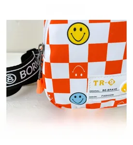 Close-up of orange checkered kids chest bag with smiley face patterns and brand tags