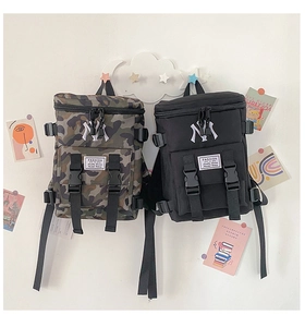 Detail of nylon backpacks with NY embroidery and fashion tags in camo and black