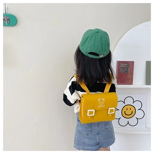 Rear view of child wearing a yellow PU leather flap backpack with cute bear print