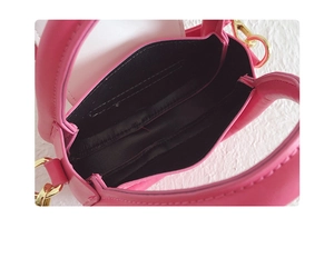 Détail du sac à main rose pour fille montrant l'intérieur noir et les crochets dorés