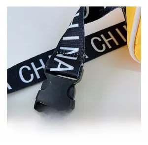 Détail d'une bandoulière en nylon noir réglable avec imprimé CHINA blanc sur un sac jaune