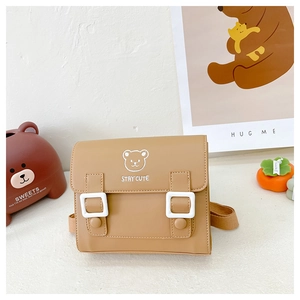 Detail of caramel faux leather children's crossbody bag with cute bear print and white buckles