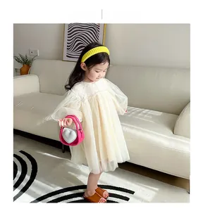 Détail d'une fille portant une robe en dentelle crème avec un sac à main cœur