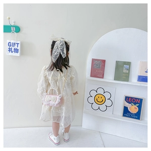 Pink lace girls crossbody bag with pearl handle and bow detail worn by child model
