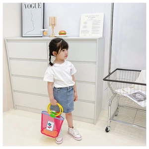 Detail of colorful mesh beach tote for kids with yellow circular handles and floral patch