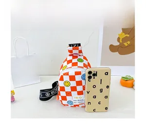 Detailed view of kids crossbody bag featuring orange checkerboard and smiley prints