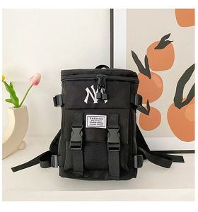 Detail of black nylon backpack with NY embroidery and fashion buckle straps on front