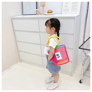 Pink mesh handbag for kids with blue flower patch and yellow round handles for beach