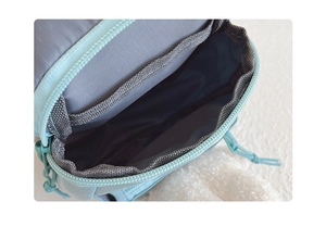 Detail of the mint green kids bag showing internal mesh pocket and grey nylon lining
