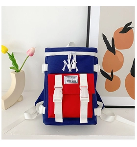 Detail of the NY embroidery logo and plastic buckle on the tricolor canvas backpack