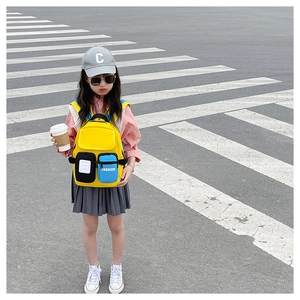 Close-up of bright yellow kids backpack with multi-pocket design and adjustable straps