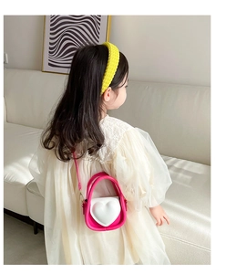 Sac à bandoulière rose cœur pour fille porté par un modèle pour le style et la taille