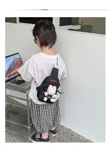 Detail display of a black canvas chest bag for kids with 3D plush bunny and embroidery