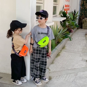 Détail de sacs bandoulière en toile pour enfants vert néon et orange vif avec sangle