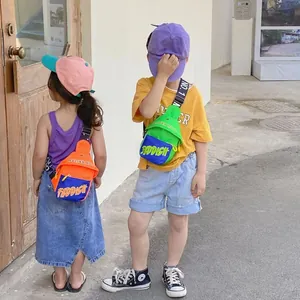 Outdoor shot of stylish kids crossbody bags with vibrant color blocking and letter print