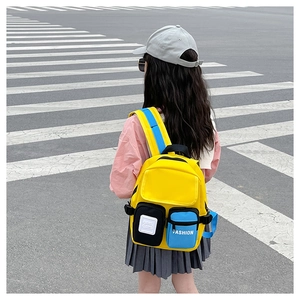 Detail of yellow and blue canvas backpack showing durable texture and functional zip pockets
