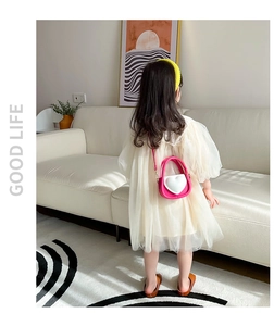 Détail d'un mini sac bandoulière cœur rose rouge pour fille dans une pièce élégante