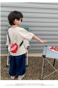 Style urbain extérieur d'un petit sac bandoulière en toile rouge pour enfant avec SUP