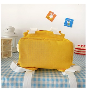 Bottom and back detail of bright yellow nylon backpack with white adjustable straps