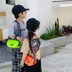 Détail de sacs bandoulière enfant vert et orange fluo avec sangles sportives