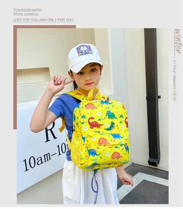 Detail of yellow children dinosaur backpack featuring side mesh pockets and cute prints