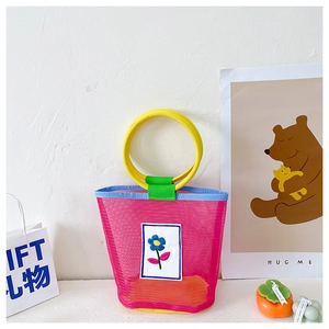 Detail of colorful mesh tote with floral embroidery and yellow circular handles