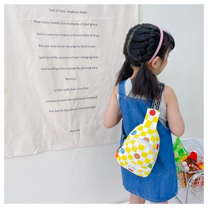 Kids checkered sling bag with yellow smiles shown on a girl with denim dress