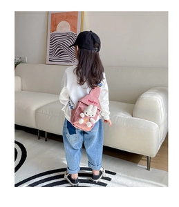 Detailed view of pink children's crossbody bag with plush rabbit and Happy slogan
