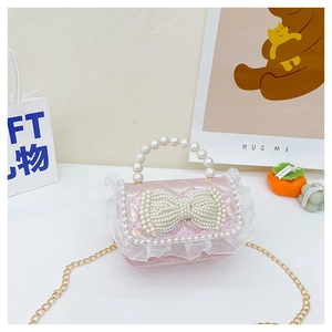 Close-up of pink glitter handbag with pearl bow, lace trim, and pearl handle detail