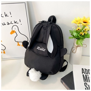 Close-up of cute black rabbit backpack featuring 3D ears and white plush pom-pom tail detail