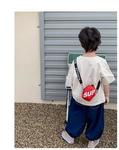 Détail du petit sac bandoulière rouge pour enfant en toile avec imprimé lettres blanches