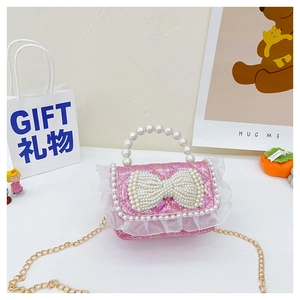 Detailed macro view of pink sequin girl's handbag with pearl bow and white lace trim