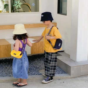 Détail de sacs bandoulière demi-lune pour enfants avec sangle logo en style urbain chic