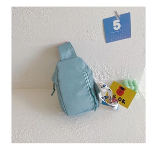 Detail of light blue kid's chest bag with colorful cartoon printed wide shoulder strap
