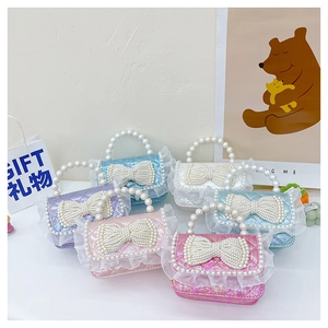 Detail view of mini pearl handbags with lace trim and large pearl bows for little girls