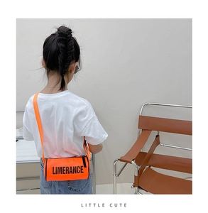 Détail du sac à bandoulière cylindrique orange vif avec texte LIMERANCE en noir gras