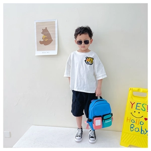 Toddler style showing a light blue multi-pocket canvas backpack with white t-shirt outfit