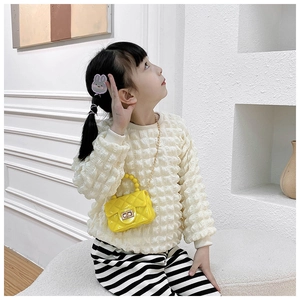 Detail view of yellow PVC jelly bag with quilted pattern and pearl handle for girls