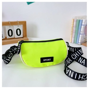 Détail du sac bandoulière en nylon vert néon avec étiquette SPORT et sangle lettrée