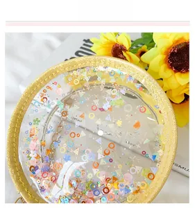 Detail shot of round transparent PVC bag with colorful heart sequins and yellow glitter trim